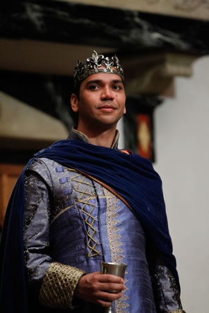 Leontes in purple royal clothes holding a cup of wine