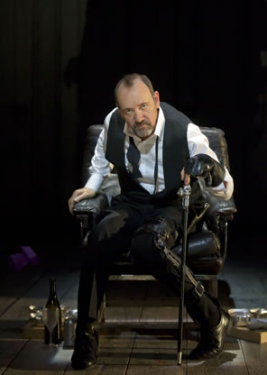 Kevin Spacey as Richard sitting in a chair with cane in left hand