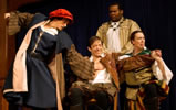 Shylock in blue renaissance robe with brown striped sleeves and red cap holds back the knife with hir right hand and has his left palm on Antonio's bare breast; Antonio sitting, wincing at what's coming, holding the hands of Salarino, while the Duke of Venice in gold robes holds Antonio's shoulder