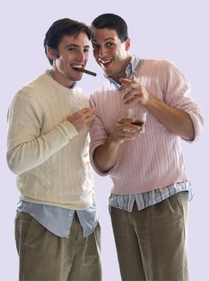 Proteus, with cigar in his mouth, talks closely with Valentine, drink in hand, both in sweaters over oxford shirts with shirttails hanging out and pleated trousers