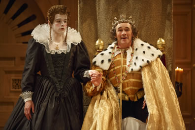 Richard in gold doublet, and shimmering gold cape with ermine coller and wearing a crown grinning and holding Lady Anne's hand. She in black dress with ruff coller looks wan