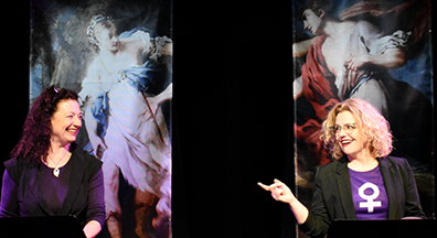 Lise Bruneau and Tonya Beckmen stand behind their music stands, looking at each other with big smiles and Beckman casually pointing a finger at Bruneau